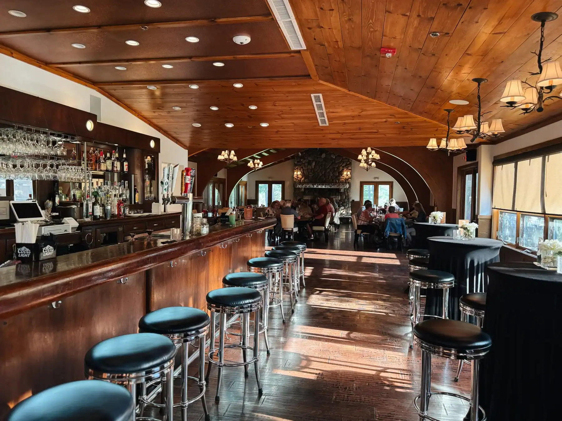 Interior view of restaurant with bar on the right and dining area in the far view