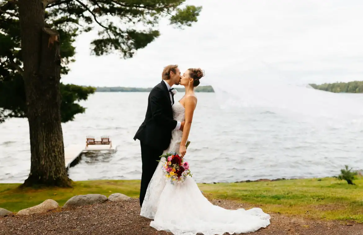 Bride and Groom kissing with lake in the background