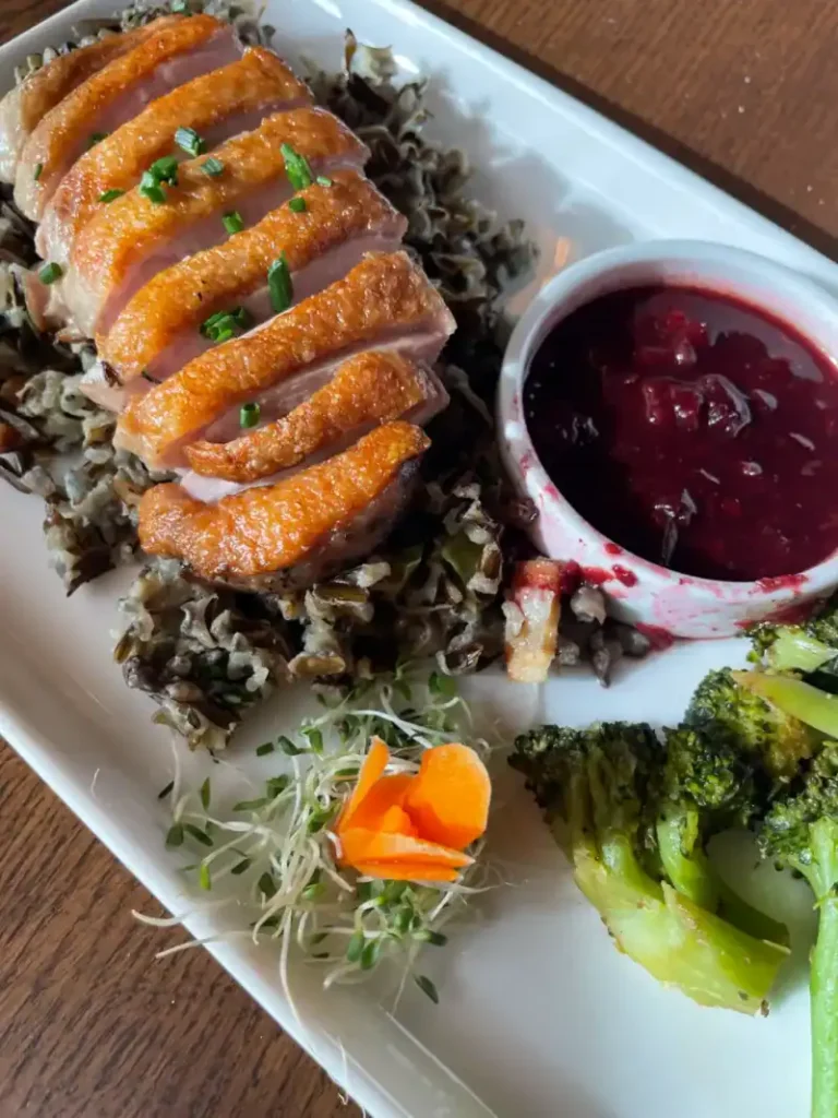 Duck breast entree over wild rice with cranberry compote, plated dinner at White Oak Grill in Manitowish Waters, Wisconsin