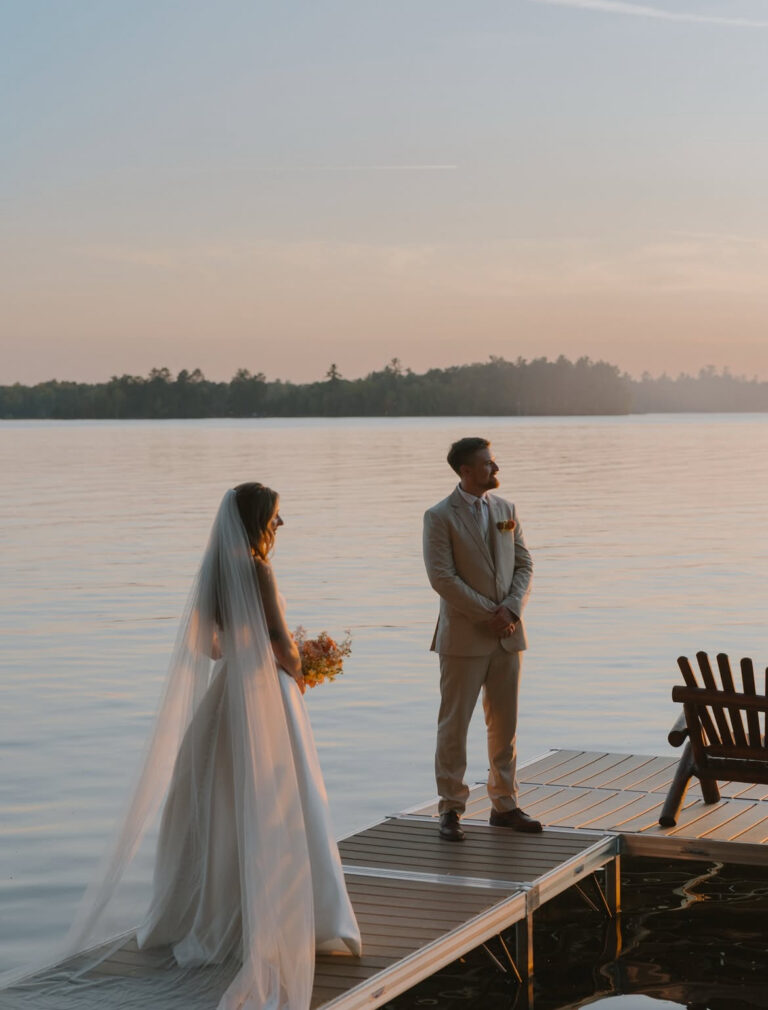 bride and groom on dock at dusk after their ceremony and vows looking over lake manitowish