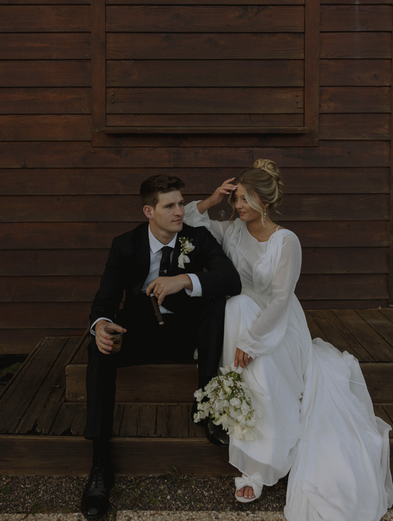 Bride and Groom sitting at the boat house at the marina at Chippewa Retreat Resort in Manitowish Waters, WI